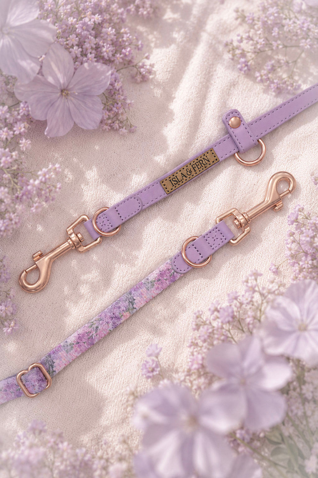 Hybrid lilac pet leashes with rose gold hardware and floral patterns, laid out on a textured cream fabric.